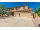 Beautiful tan two-story home, stone accents, three-car garage and desert landscaping at 26272 N 73Rd Dr, Peoria, AZ 85383