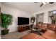 Cozy living room with a large brown sectional sofa, ceiling fan and large screen television at 26272 N 73Rd Dr, Peoria, AZ 85383