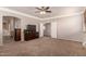 Large main bedroom suite with neutral carpet, ceiling fan, and sitting area at 26272 N 73Rd Dr, Peoria, AZ 85383