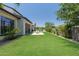 Spacious backyard with a lush lawn, a fire pit area, and a glimpse of the inviting pool beyond at 2630 E Lovebird Ln, Gilbert, AZ 85297