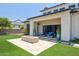 Large backyard with a stone fire pit, covered patio featuring comfortable blue seating, and a well-manicured lawn at 2630 E Lovebird Ln, Gilbert, AZ 85297