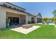 Expansive backyard featuring a stone fire pit, covered patio with comfortable seating, and lush green lawn at 2630 E Lovebird Ln, Gilbert, AZ 85297
