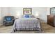 Comfortable bedroom with a queen bed, a cozy armchair, and beautiful gray wood-look floors at 2630 E Lovebird Ln, Gilbert, AZ 85297