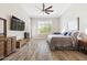 This bedroom has wood floors, a ceiling fan, and a large window that provides natural light at 2630 E Lovebird Ln, Gilbert, AZ 85297