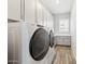 Modern laundry room with top of the line white washer/dryer units and plenty of storage at 2630 E Lovebird Ln, Gilbert, AZ 85297