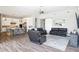 Open concept living room and kitchen featuring wood floors, white cabinets and an island with seating at 2630 E Lovebird Ln, Gilbert, AZ 85297
