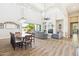 Spacious living room with high ceilings, wood floors, fireplace, gray sofas, and elegant chandelier at 2630 E Lovebird Ln, Gilbert, AZ 85297