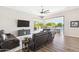 Bright living room featuring leather furniture, wood floors and an open sliding door to the outdoor pool at 2630 E Lovebird Ln, Gilbert, AZ 85297