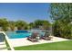 Tranquil pool area with a cascading waterfall feature, comfortable lounge chairs, and lush greenery at 2630 E Lovebird Ln, Gilbert, AZ 85297