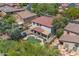 Aerial view of a backyard featuring a pool, patio, and covered seating area, surrounded by lush greenery and desert landscaping at 27053 N 172Nd Ln, Surprise, AZ 85387