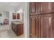 Bathroom featuring double sinks, granite countertops, and dark wood cabinets, with adjacent hallway at 27053 N 172Nd Ln, Surprise, AZ 85387