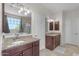 Bathroom featuring dual vanities with granite countertops, tiled floors, and ample natural light at 27053 N 172Nd Ln, Surprise, AZ 85387