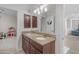 Bathroom featuring double sinks, granite countertops, and dark wood cabinets, with neutral color scheme at 27053 N 172Nd Ln, Surprise, AZ 85387