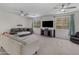 Spacious living room with neutral walls, carpet, ceiling fans, large windows, and cozy seating for relaxing and entertaining at 27053 N 172Nd Ln, Surprise, AZ 85387