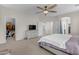 Bright main bedroom featuring carpet, ceiling fan, and an ensuite bathroom at 27053 N 172Nd Ln, Surprise, AZ 85387