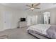 Spacious main bedroom featuring a ceiling fan, dresser with TV, and neutral carpeting throughout at 27053 N 172Nd Ln, Surprise, AZ 85387