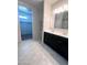 Elegant bathroom featuring double sinks, dark cabinets, and a walk-in closet at 29906 W Whitton Ave, Buckeye, AZ 85396