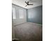 Cozy bedroom features plush carpeting, dual windows, and a modern ceiling fan at 29906 W Whitton Ave, Buckeye, AZ 85396