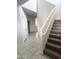 Hallway with neutral tiles and a staircase adjacent the entry, leading to the upper level of the home at 29906 W Whitton Ave, Buckeye, AZ 85396