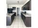 Kitchen featuring granite countertops and modern dark cabinets with neutral tiled flooring and stainless steel appliances at 29906 W Whitton Ave, Buckeye, AZ 85396