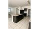 Kitchen with granite countertops, neutral tiled floors and modern dark cabinets at 29906 W Whitton Ave, Buckeye, AZ 85396