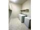 Bright laundry room featuring a washer, dryer, freezer, and built-in shelving for storage at 29906 W Whitton Ave, Buckeye, AZ 85396