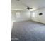 Spacious living room with neutral carpet and natural light from the windows at 29906 W Whitton Ave, Buckeye, AZ 85396