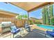 Covered patio with outdoor chairs and grill near the pool in the backyard at 3128 W Belle Ave, San Tan Valley, AZ 85144
