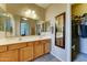 Bright bathroom with double sinks, wood cabinets, a framed mirror, and walk in closet at 3128 W Belle Ave, San Tan Valley, AZ 85144