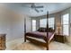 Tranquil bedroom featuring a four-poster bed, neutral tones, and natural light from multiple windows at 3128 W Belle Ave, San Tan Valley, AZ 85144