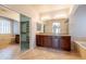 Bright bathroom featuring double sinks, cabinets, soaking tub, and tile floors at 3173 E Canyon Way, Chandler, AZ 85249
