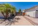 Long driveway leading to a private backyard gate, surrounded by lush landscaping and palm trees at 3173 E Canyon Way, Chandler, AZ 85249