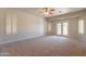 Large main bedroom with plush carpet, ceiling fan, and private access to outdoor space at 3173 E Canyon Way, Chandler, AZ 85249