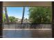 This balcony view overlooks palm trees, lush landscaping, and a peaceful neighborhood street at 330 W Maryland Ave # 207, Phoenix, AZ 85013