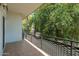 A view of the neighborhood from the balcony, framed by green trees and a unique iron railing at 330 W Maryland Ave # 207, Phoenix, AZ 85013