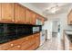 Galley kitchen with wood cabinetry, granite countertops, and white appliances at 330 W Maryland Ave # 207, Phoenix, AZ 85013