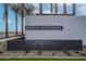 Community entrance featuring a modern sign, decorative fence, and lush landscaping at 3853 S Buttercup Cir, Mesa, AZ 85212