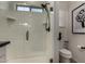 Modern bathroom featuring a glass enclosed shower with black fixtures, toilet, and artistic wall decor at 4548 S Renaissance Dr # 103, Gilbert, AZ 85297