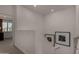 Bright hallway featuring neutral walls, artwork, and views into another room at 4548 S Renaissance Dr # 103, Gilbert, AZ 85297