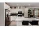 Modern kitchen featuring white cabinets, stainless steel appliances, and a large island with seating at 4548 S Renaissance Dr # 103, Gilbert, AZ 85297