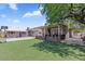 Large backyard with covered patio, artificial turf, and additional storage shed at 4822 N 63Rd Ln, Phoenix, AZ 85033