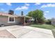 Backyard includes covered patio with stone accents, well-maintained lawn, and mature tree at 4822 N 63Rd Ln, Phoenix, AZ 85033