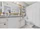 Bright bathroom featuring wood mirror frame, gray counters, white cabinets and a tiled floor at 4822 N 63Rd Ln, Phoenix, AZ 85033