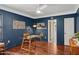Home office has a glass desk, hardwood flooring, natural light, and sophisticated dark blue walls at 522 W Cambridge Ave, Phoenix, AZ 85003
