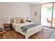 Sunlit bedroom features a queen bed, side tables, a rug, and sliding door to outdoor patio at 5246 N 20Th St # B1, Phoenix, AZ 85016