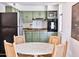 Charming kitchen with sage green cabinets, modern appliances, and an adjacent dining area at 5246 N 20Th St # B1, Phoenix, AZ 85016