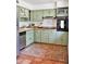 Charming kitchen with sage-green cabinets, butcher block countertops, stainless steel appliances and a rustic terracotta floor at 5246 N 20Th St # B1, Phoenix, AZ 85016