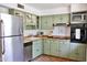 Charming kitchen with sage-green cabinets, butcher block countertops, stainless steel appliances and a rustic terracotta floor at 5246 N 20Th St # B1, Phoenix, AZ 85016