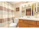 Well-lit bathroom with a shower-tub, vanity with a wooden cabinet, mirror and attractive decor at 6422 N 77Th Way, Scottsdale, AZ 85250