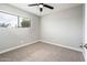 Bedroom with neutral carpet, a ceiling fan, and a large window with natural light at 6627 S 42Nd Pl, Phoenix, AZ 85042